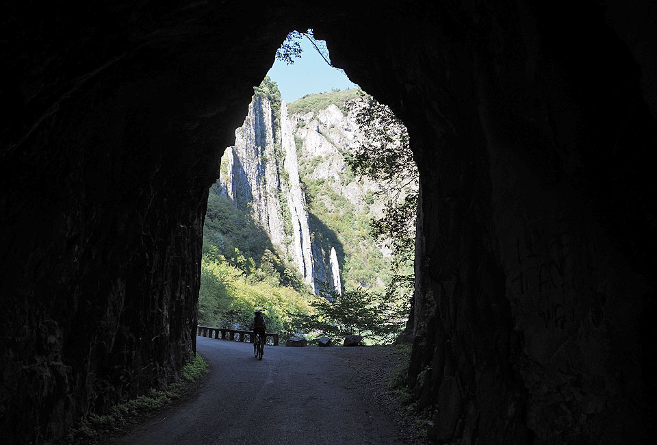 Durch alte Tunnels führt der Radweg an den Felswänden entlang